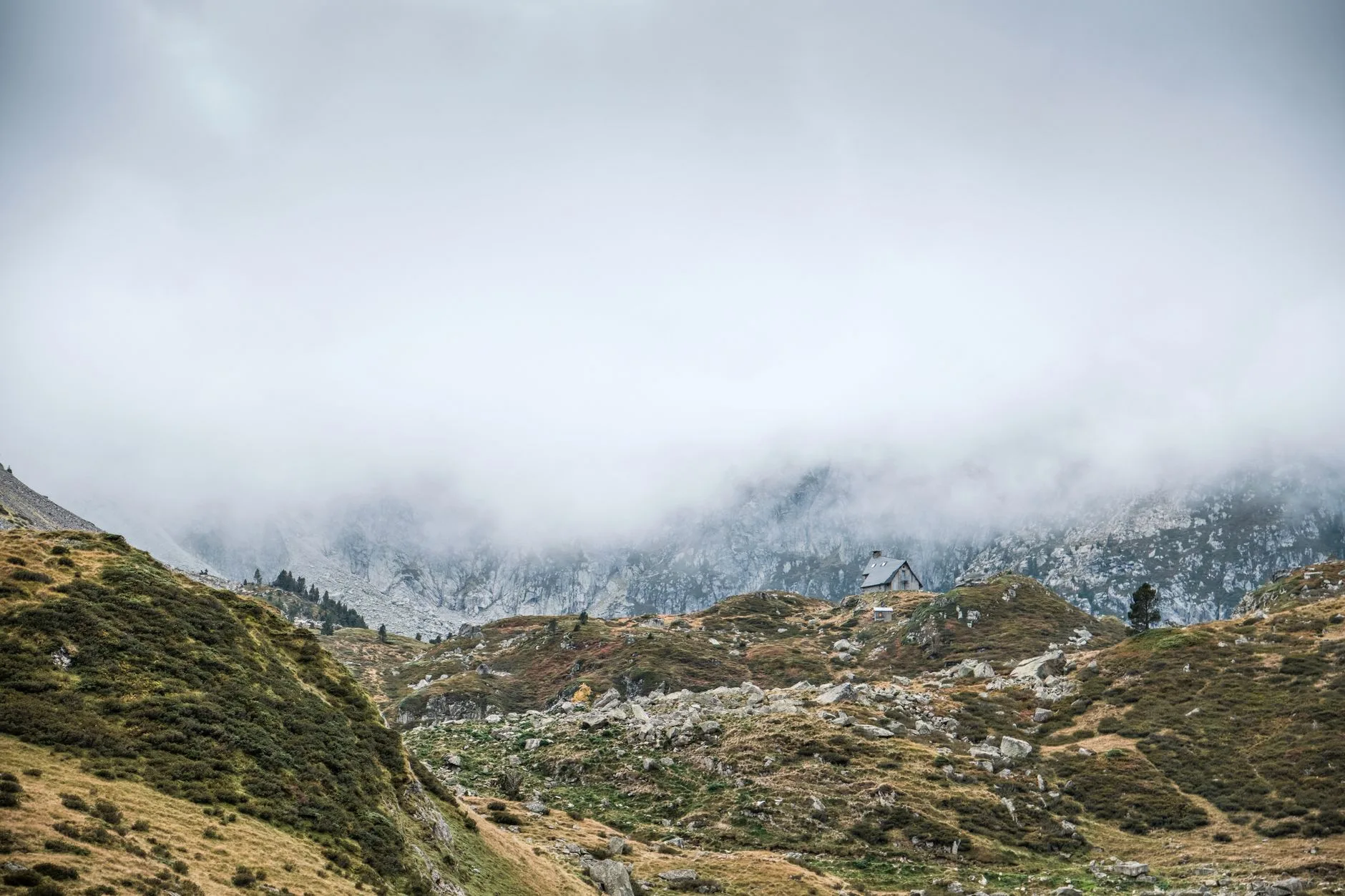 Randonneur consultant son portefeuille devant un refuge de montagne sur le GR20 en Corse